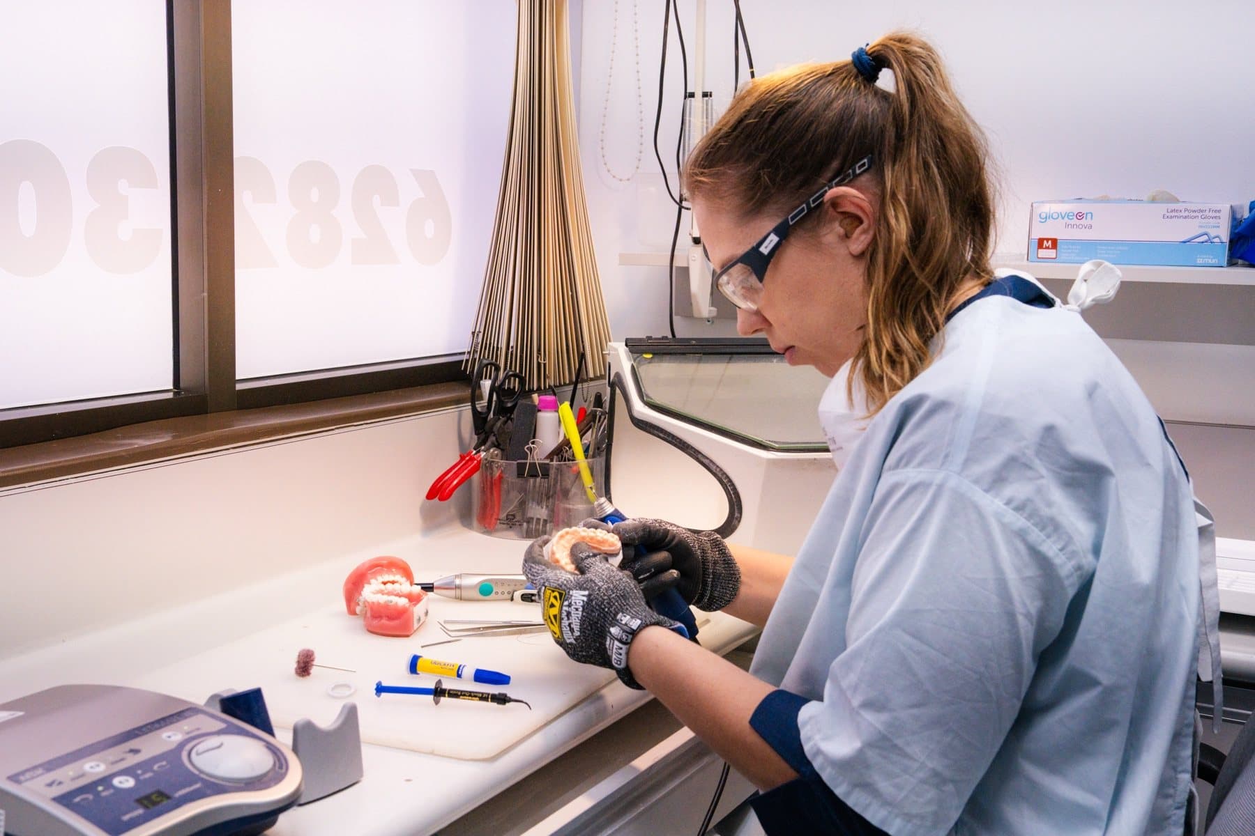 Lab technician fabricating a custom retainer in the practice lab