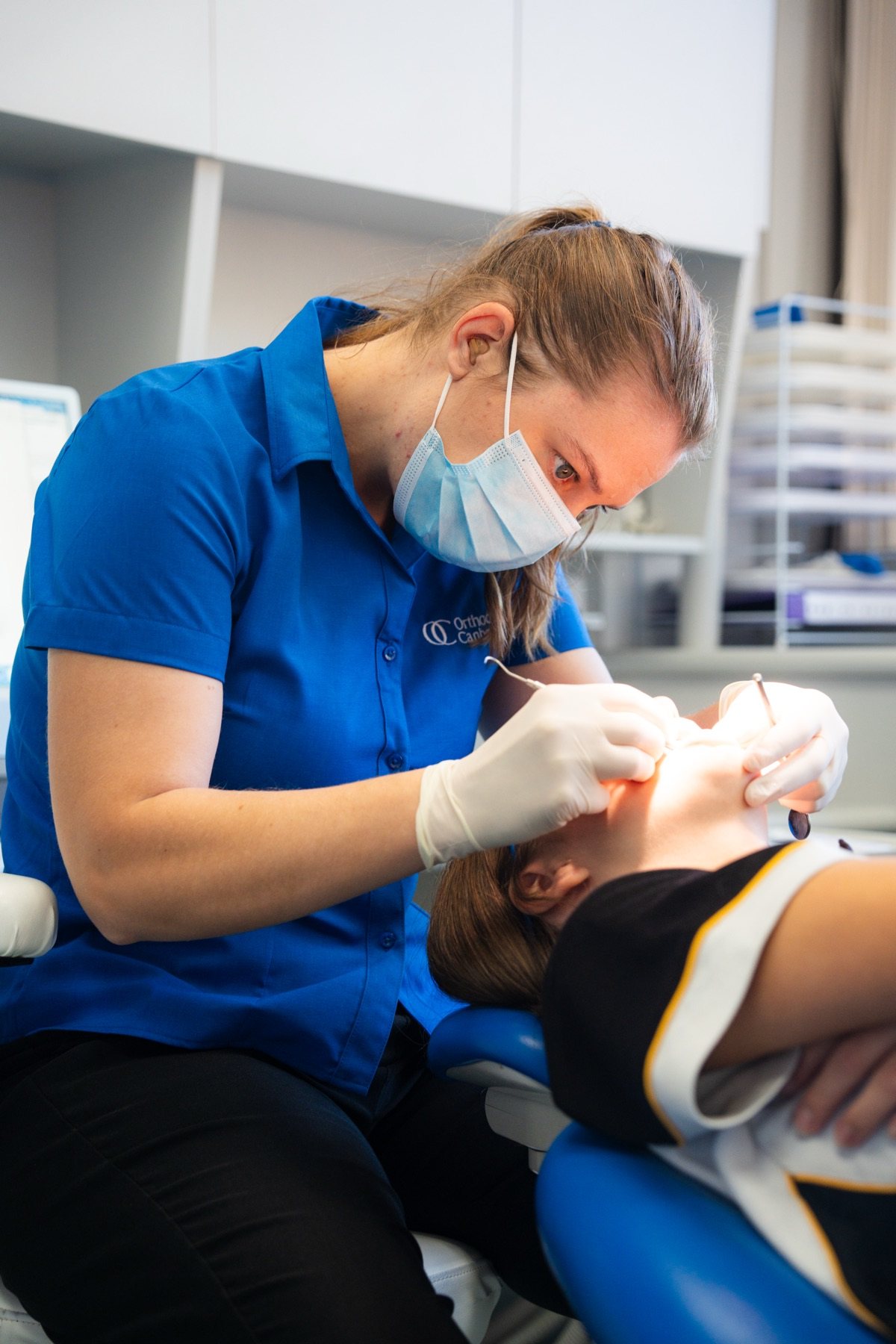 Dental assistant adjusting metal braces