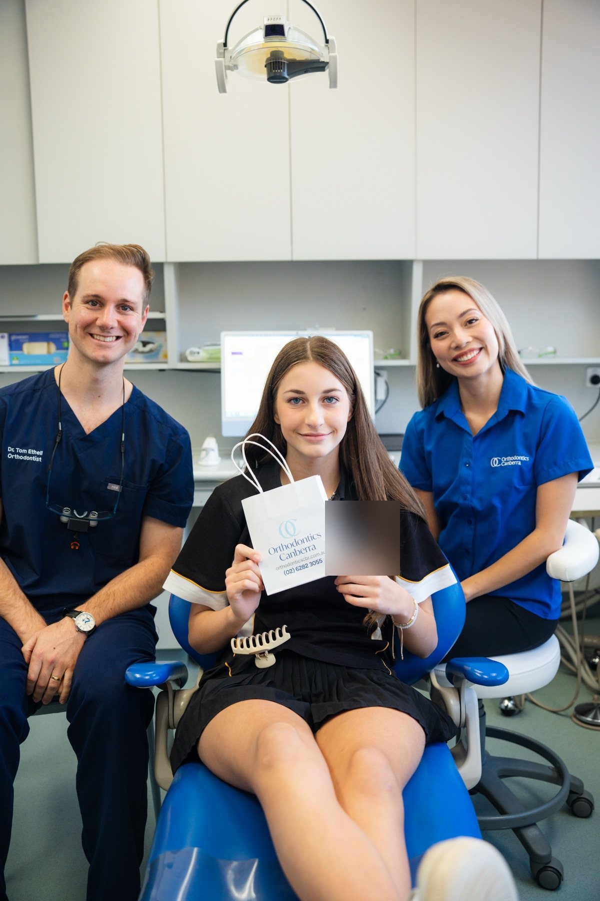 Patient with their post-treatment gift bag and the care team